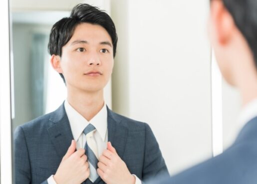 鏡の前で身支度する男性