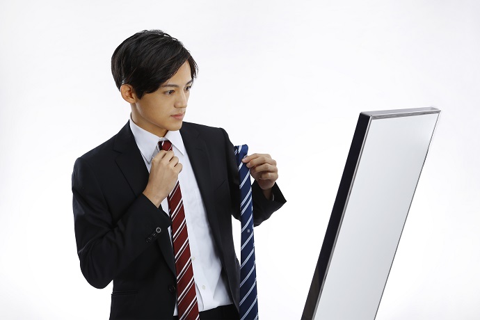 鏡の前でネクタイを選ぶ就活生