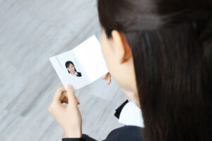 撮影した就活証明写真を見る女性